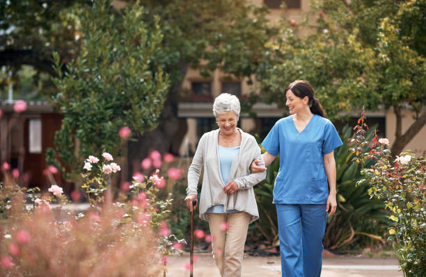 Shot of a caregiver and her patient out for a walk in the garden